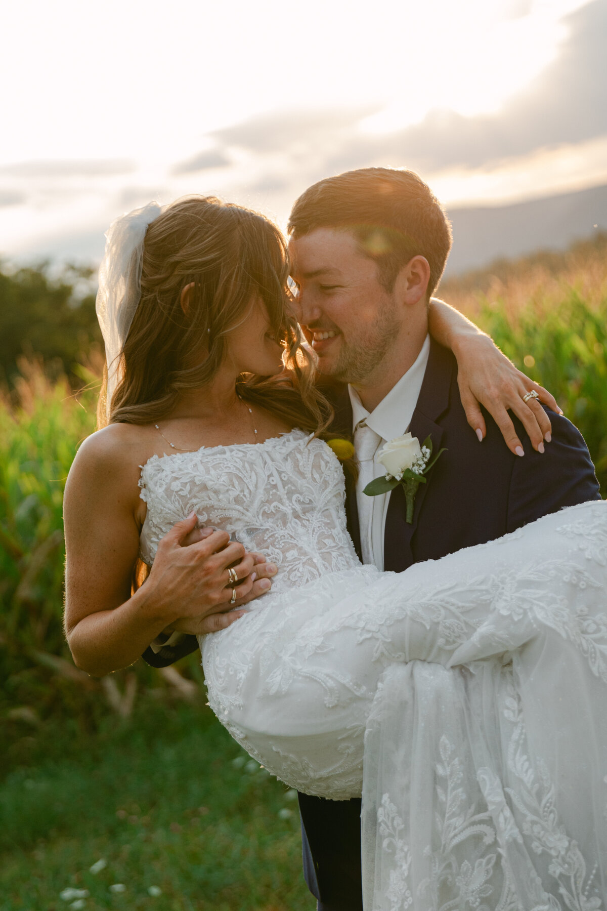 bride-smiling-groom-arms-sunset