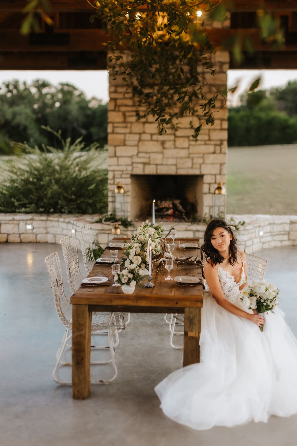 bride sitting beside a decorated table with large fireplace int he background