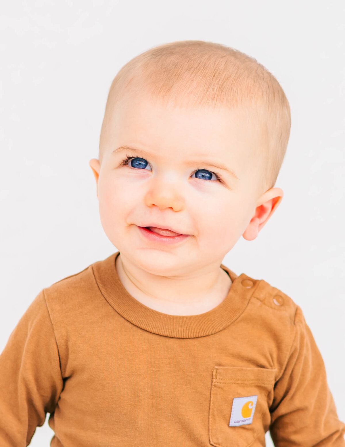 Six-month-old baby boy smiling on white backdrop — fine art infant portrait by S. Reed Photography