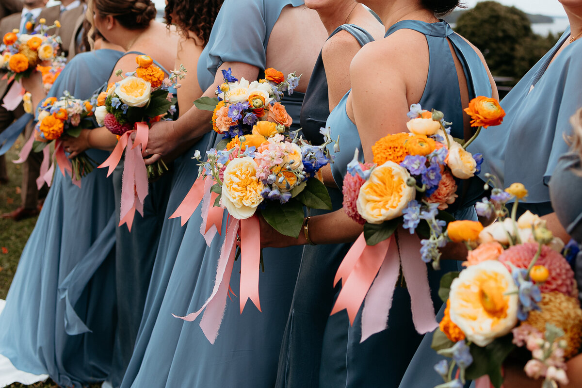 New England wedding photography: bridesmaids lined up with their flowers by Mimi and Mum. In powder blue dresses