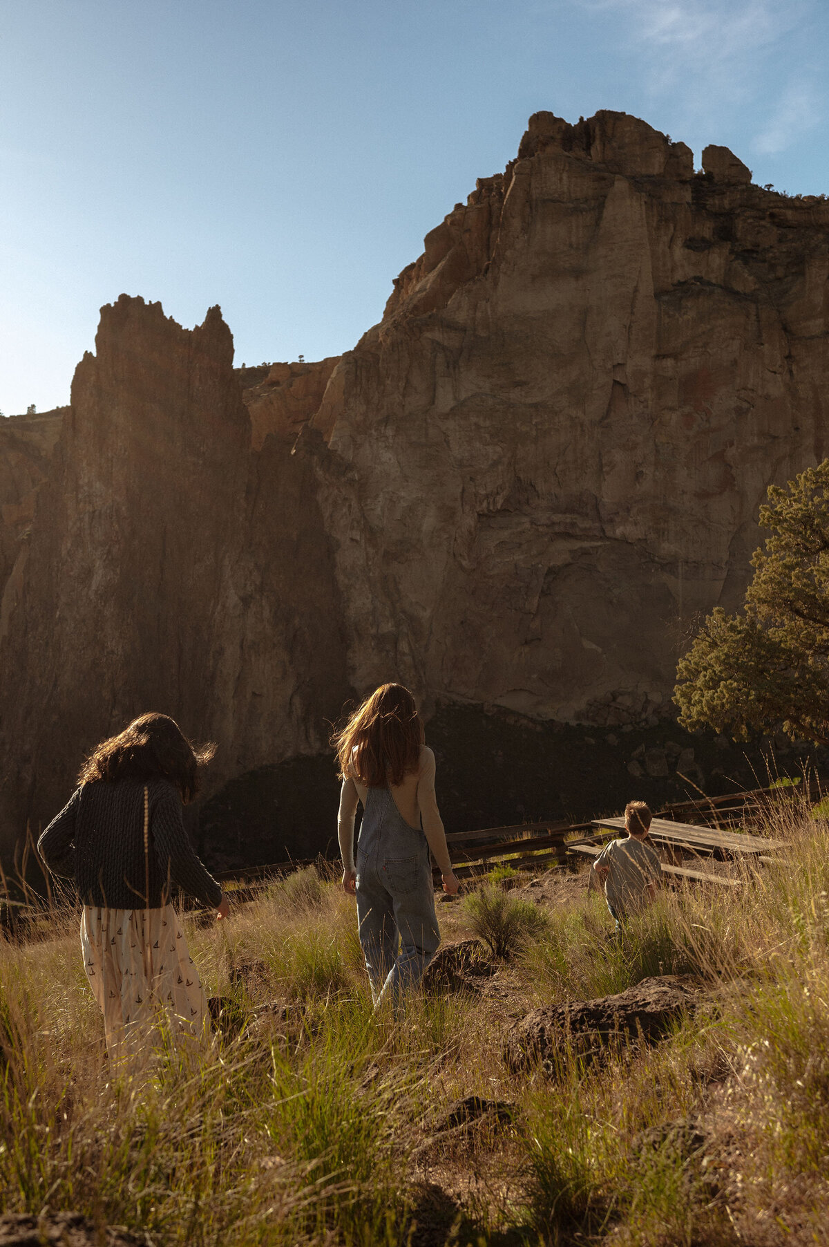 candid photo of family fun with a mother and children walking near the towering rocks of Smith Rock