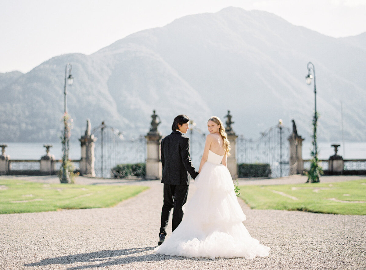 Bride and groom at their Villa Sola Cabiati wedding on Lake Como in Italy with the mountains and the lake behind them photographed by Lake Como wedding photographer