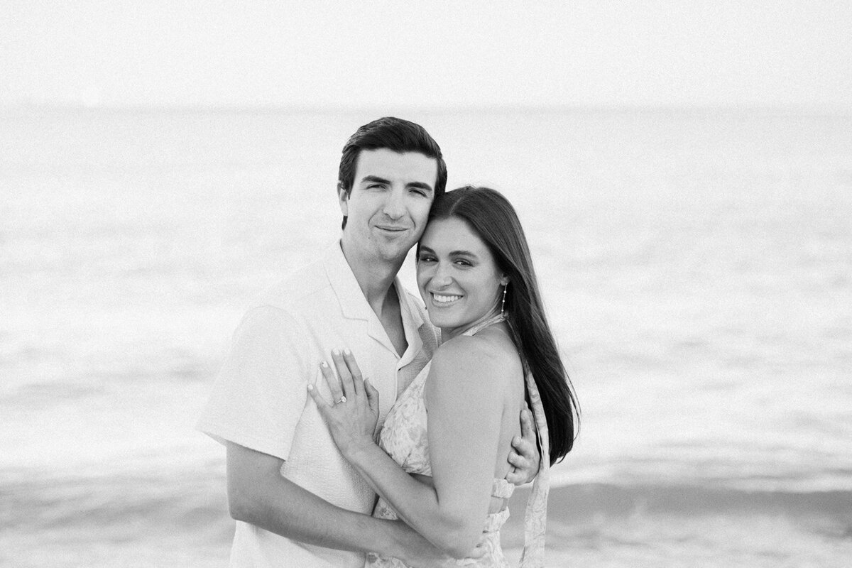 Rebecca and Graysen embrace in a heartfelt moment, captured in black and white, during their elegant beachside engagement session at Marriott Hotel Fort Lauderdale.