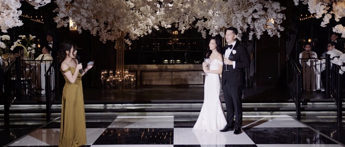 Couple enjoying speeches from the maid of honor at their wedding in dallas