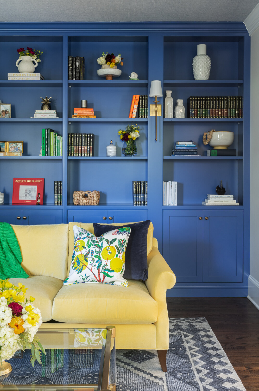 bright yellow sofa with blue built-in bookshelves in the back