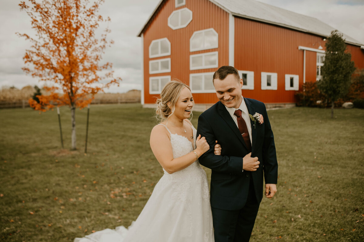 bride and groom wedding portrait in front of a red barn outside