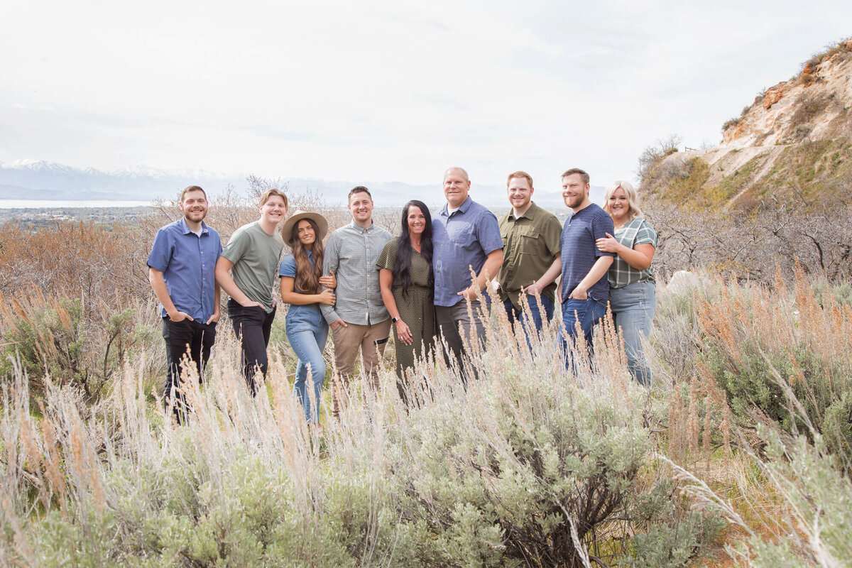 Family portrait of nine adults in green , tan, and blue  at Rock Canyon, captured by las vegas family photographer, Jessica Bowles