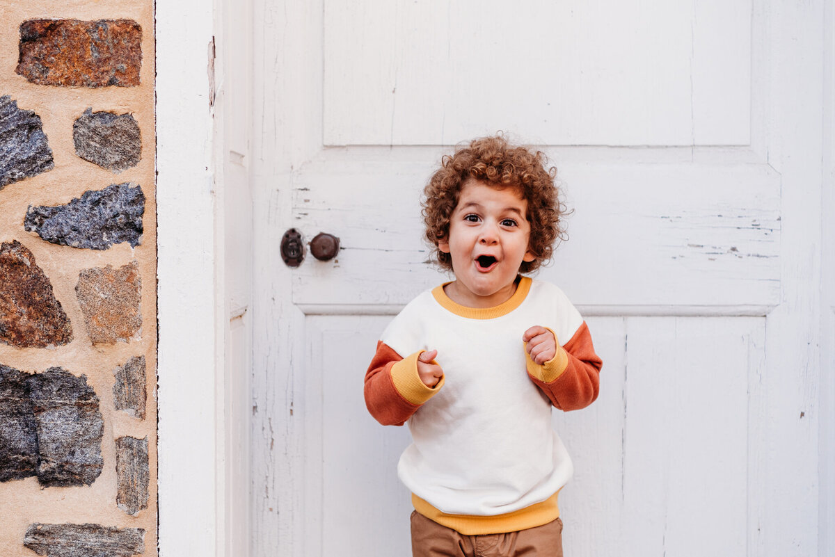 Young boy with curly hair showing a super excited face.  Featured on page about philadelphia photographer reviews