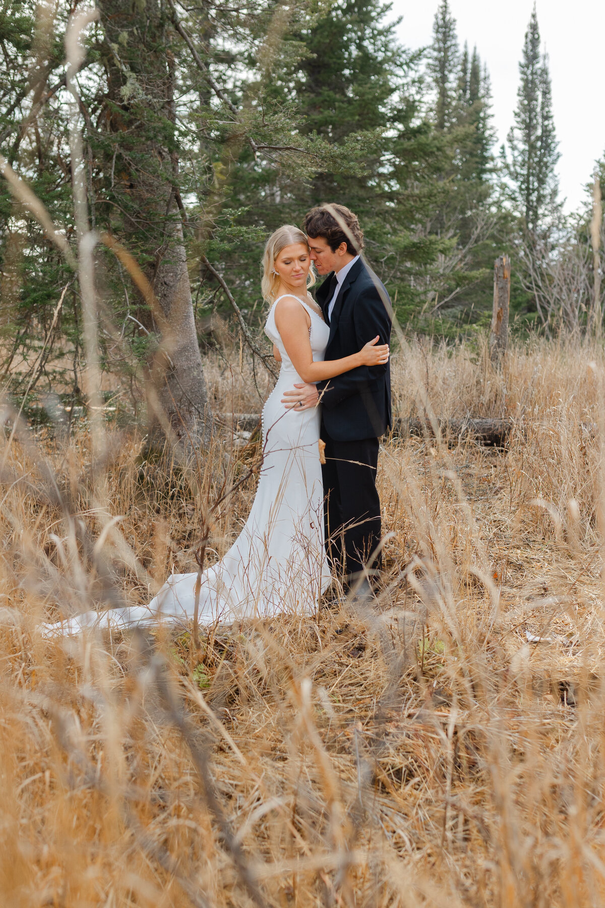At a north shore elopement, the couple poses in a grassy field with a Duluth wedding photographer, S Jacobson Photography.