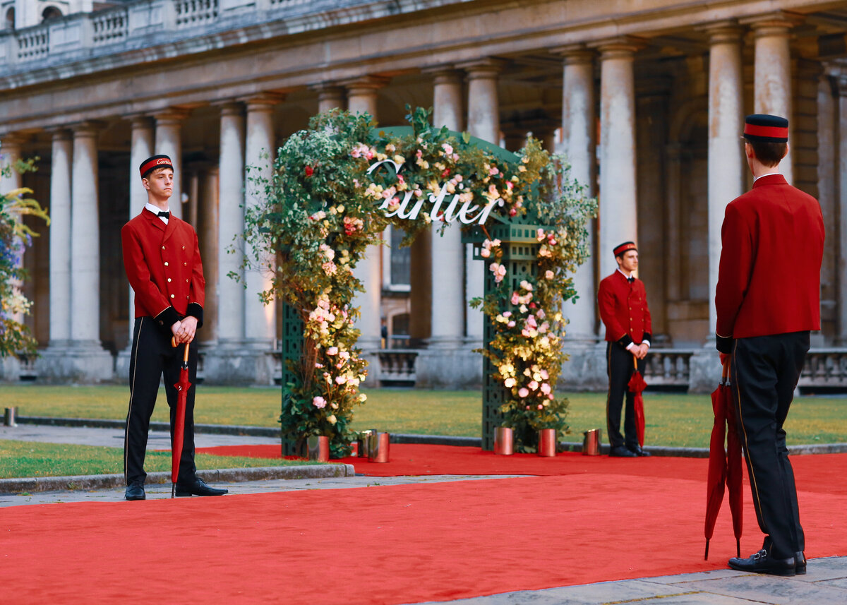 A red carpet with a floral arch at the Old Royal Naval College in London for an event for Cartier.