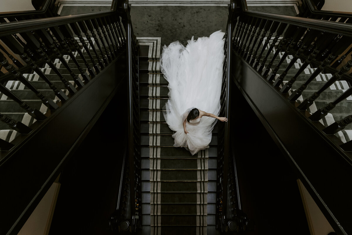 the bride walking down the stairs in the raffles hotel