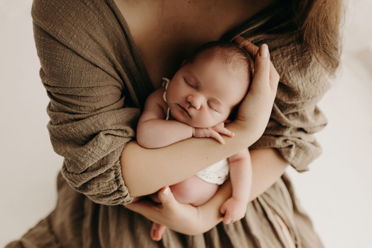 Tender moment captured by a Mullingar newborn photographer: sleeping baby in mother's arms