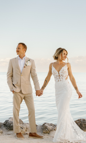 Bride and groom walking hand in hand on a serene beach at Cheeca Lodge, captured by Claudia Amalia, a wedding and lifestyle photographer based in Miami and Florida Keys, South Florida. Destination weddings available.