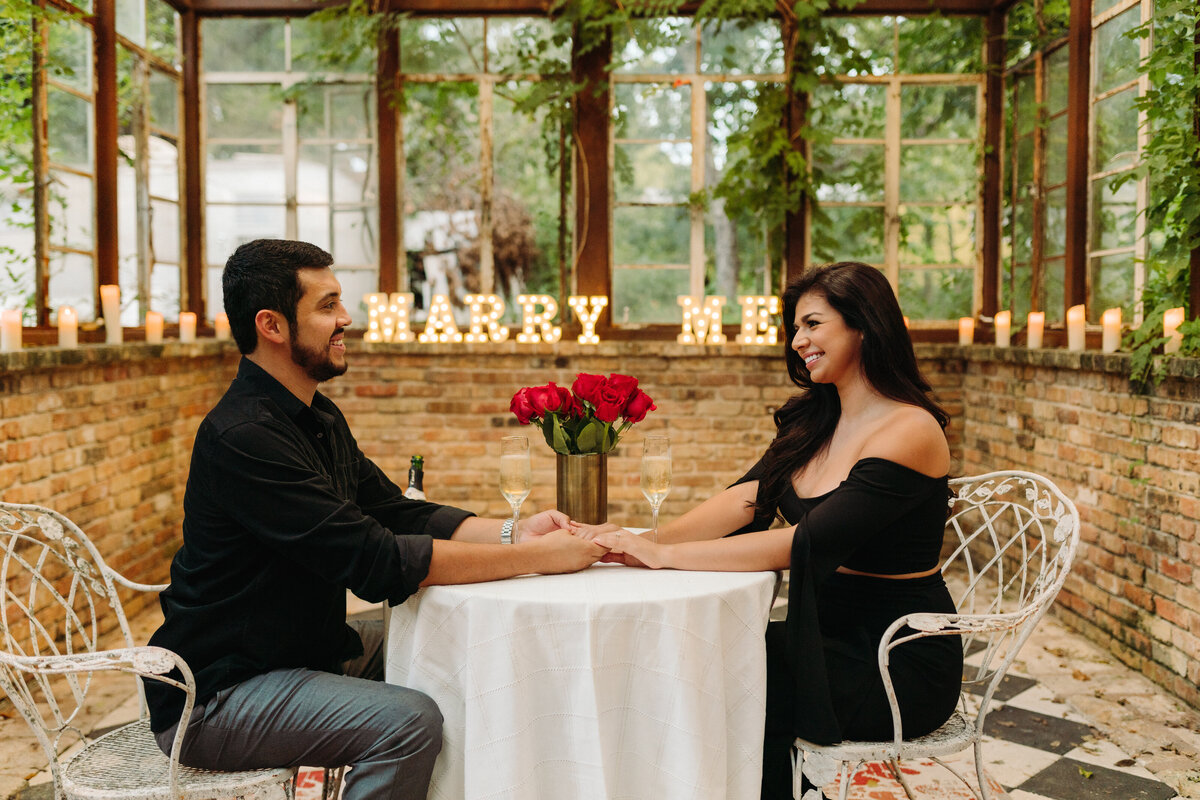How to plan your proposal in Austin  couple sitting across from each other at table holding hands