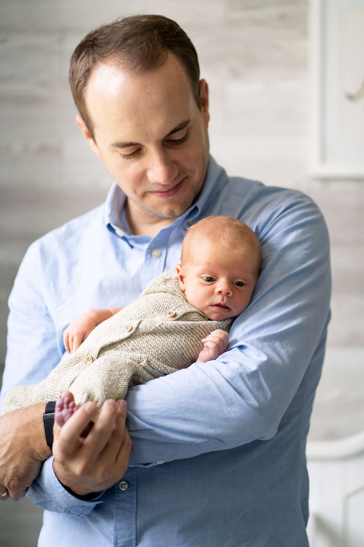Father holding newborn baby during Atlanta newborn photography session