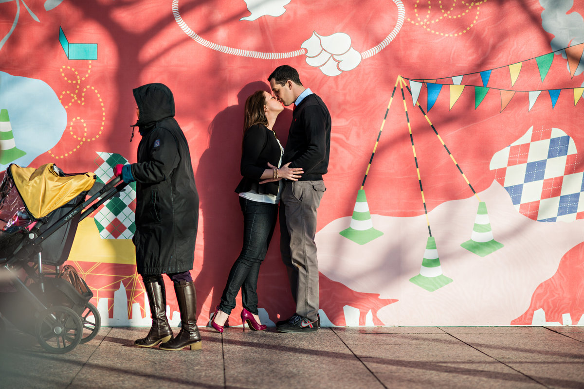 A couple kiss while pass them by on the nyc streets.