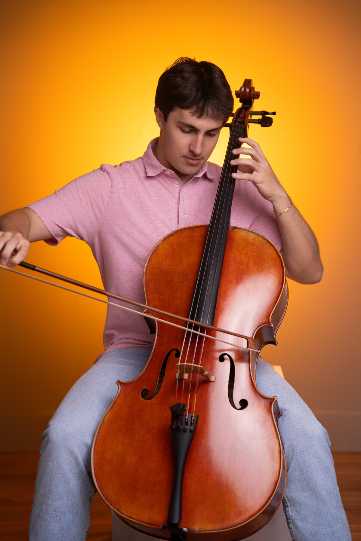 high school senior boy plays the an instument with creative lighting in a portrait studio