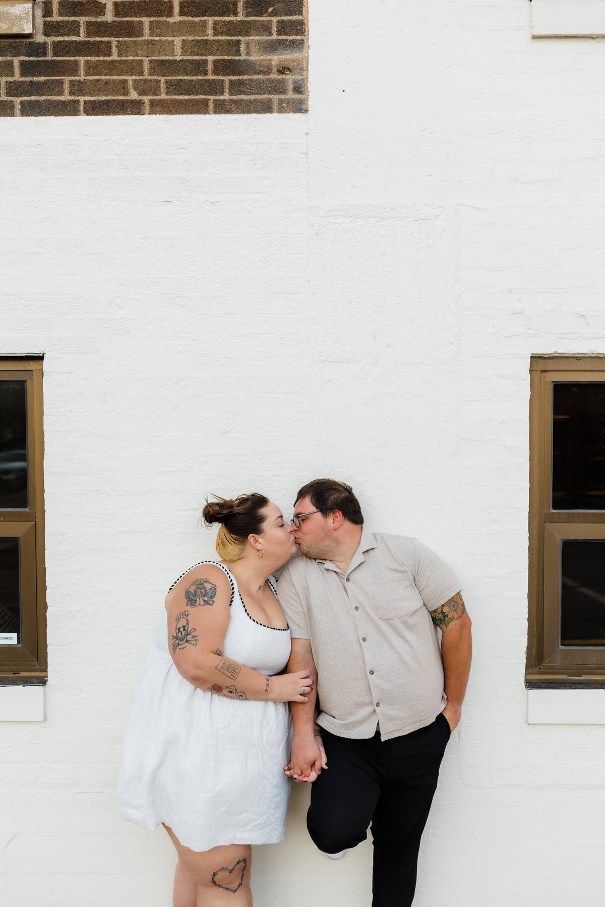 Bride and groom sharing a kiss outside a brick building in South Bend, Indiana.