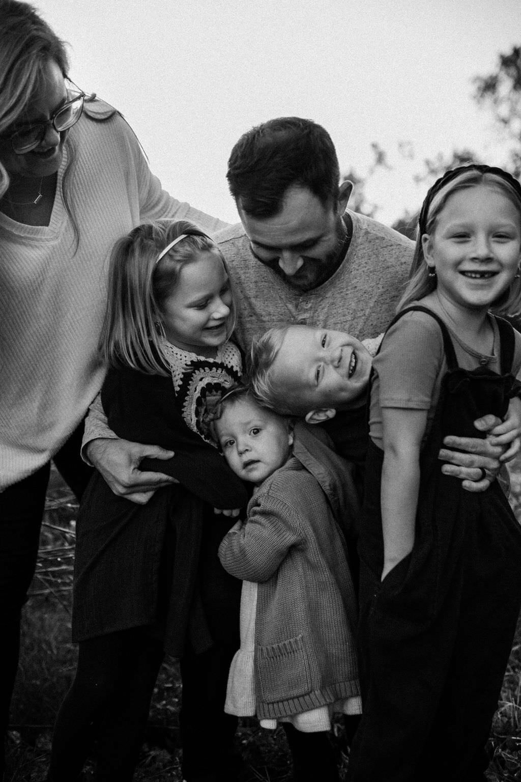 black and white image father embracing children