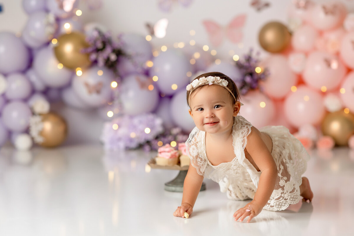 One year old Tampa baby girl enjoying a personalized luxury cake smash session with elegant decorations
