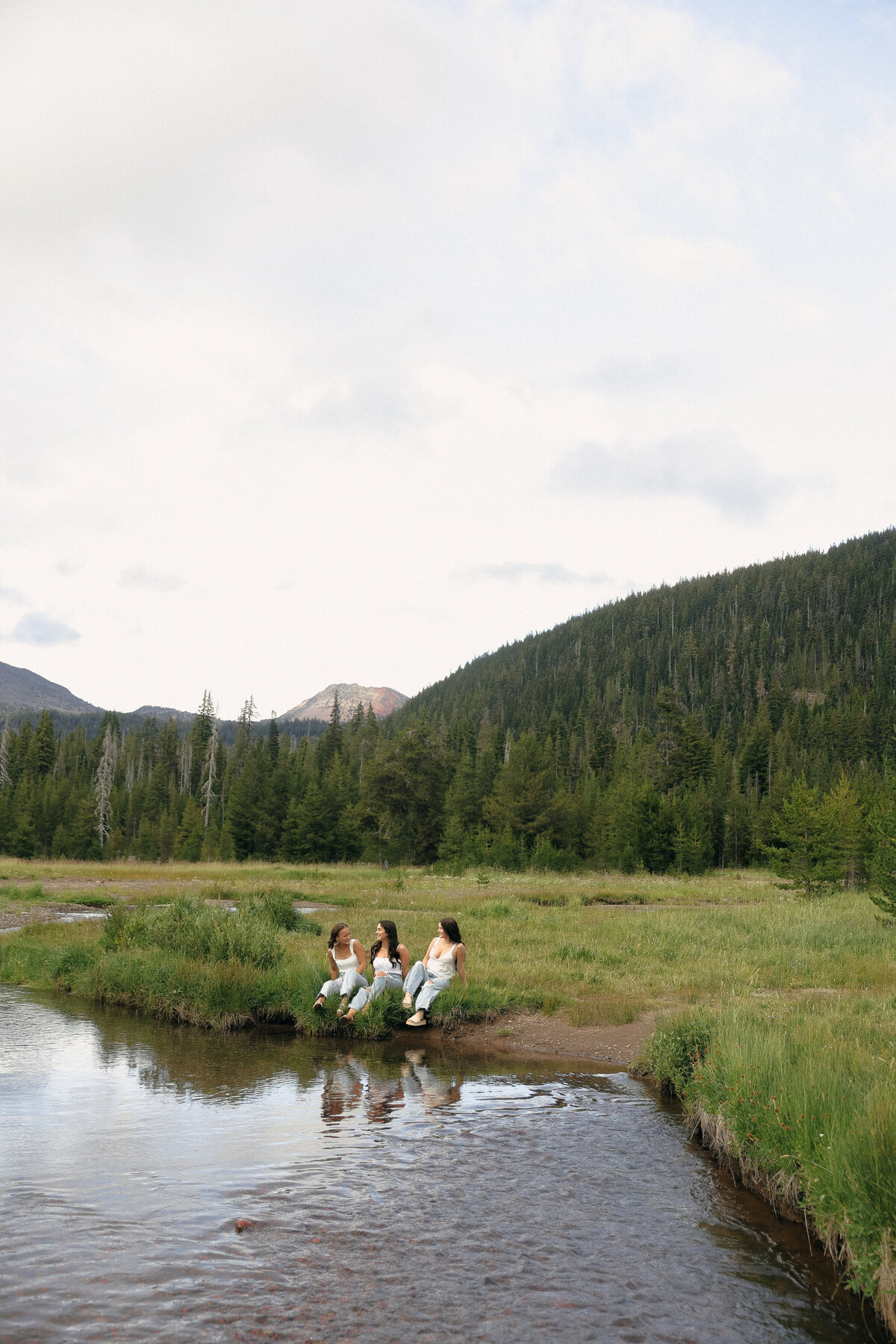 Dreamy Outdoor Senior Portrait of Girl in White Dress Laughing in Wildflower Field