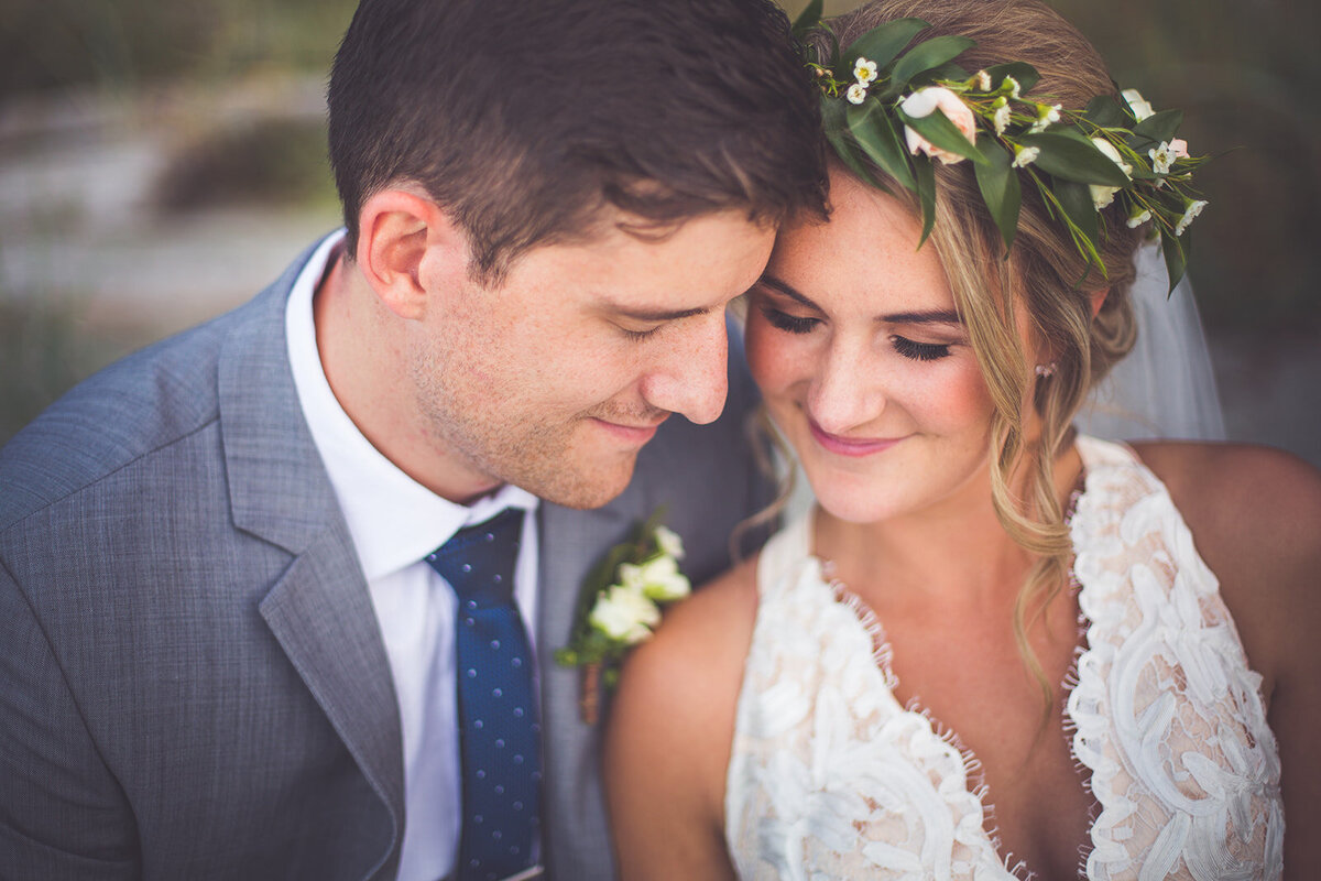 A bride and groom smiling with their eyes closed.