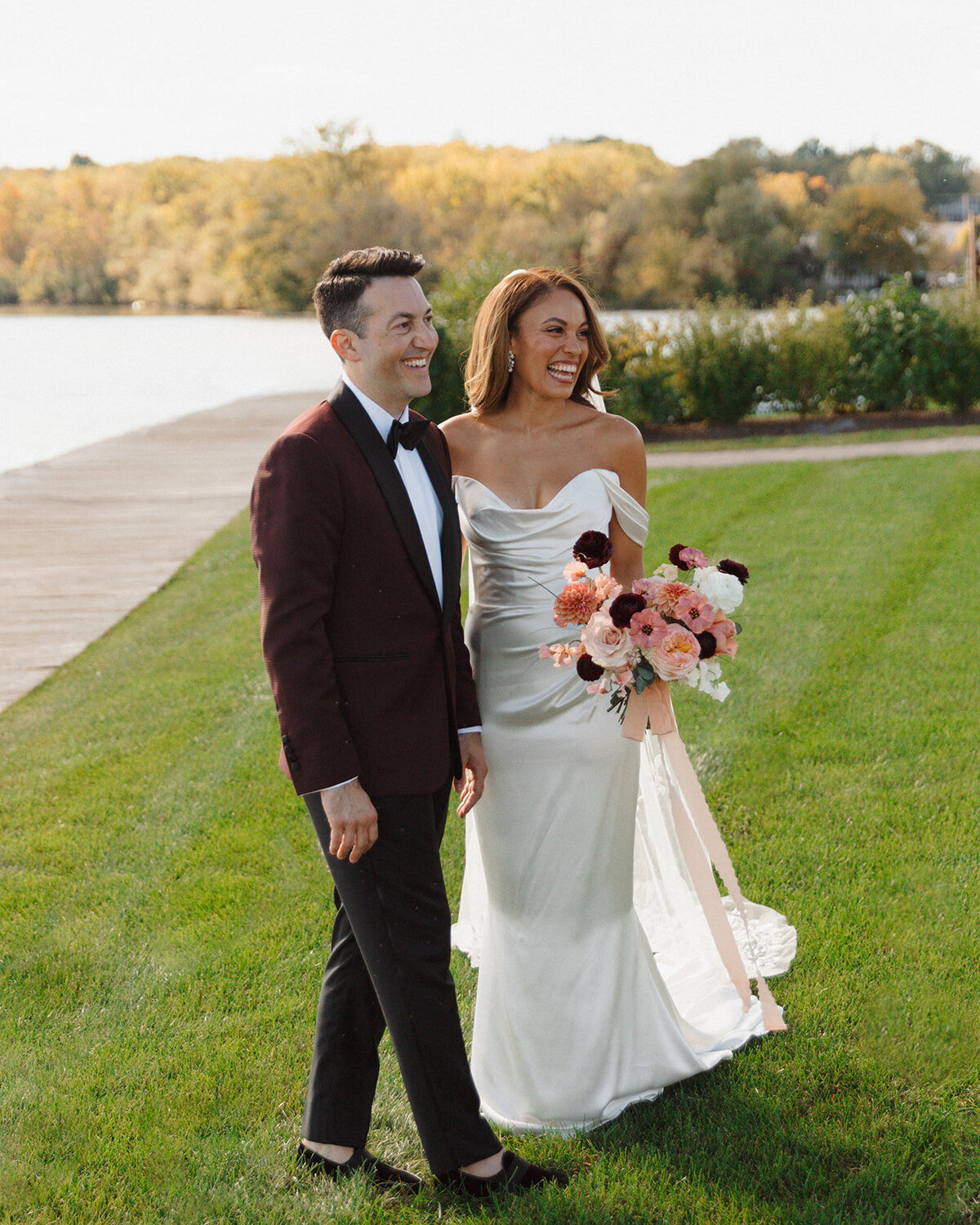 The bride and groom take a walk by the water at The Lake House on Canandaigua