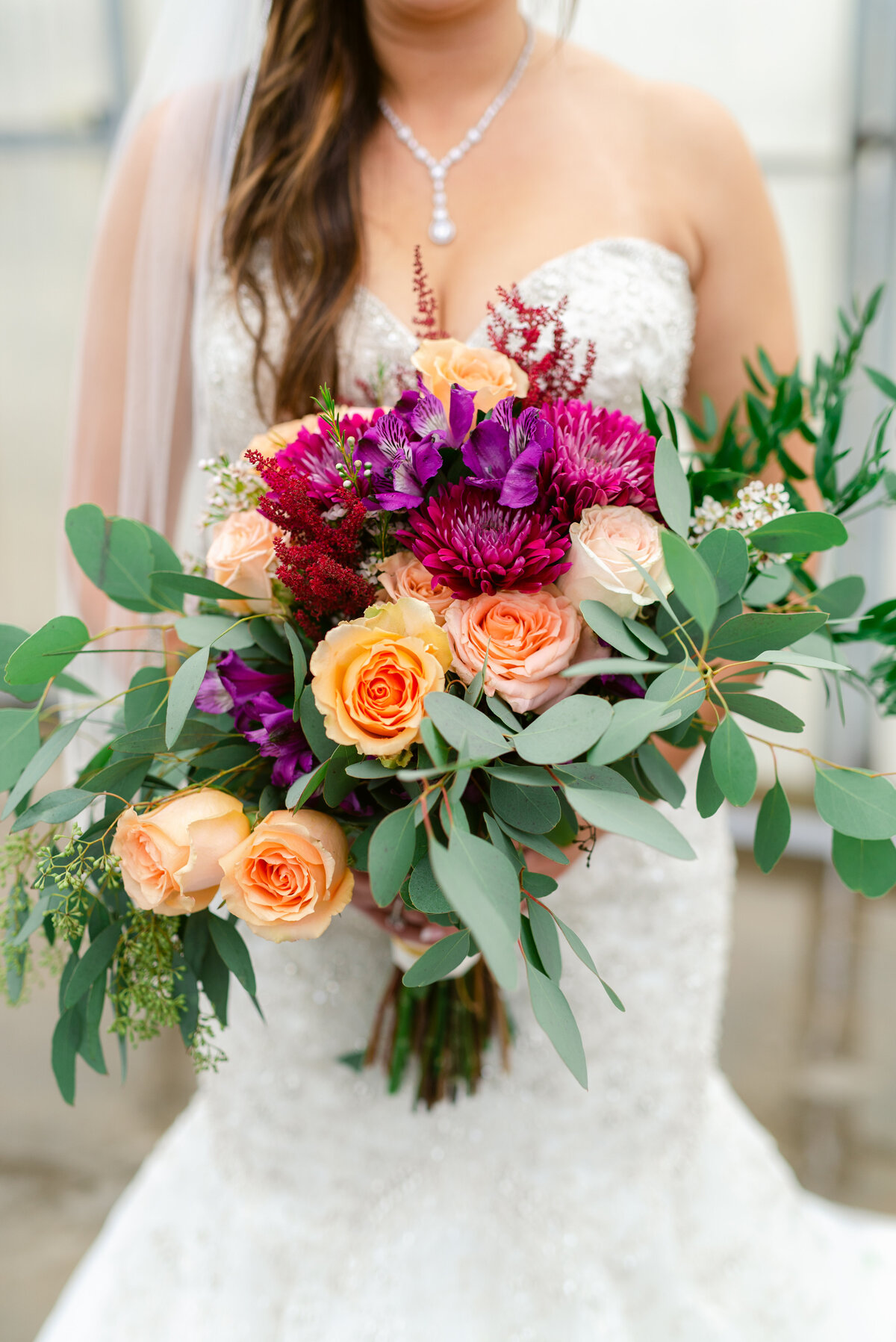 Bride holding a bright bouquet of flowers.
