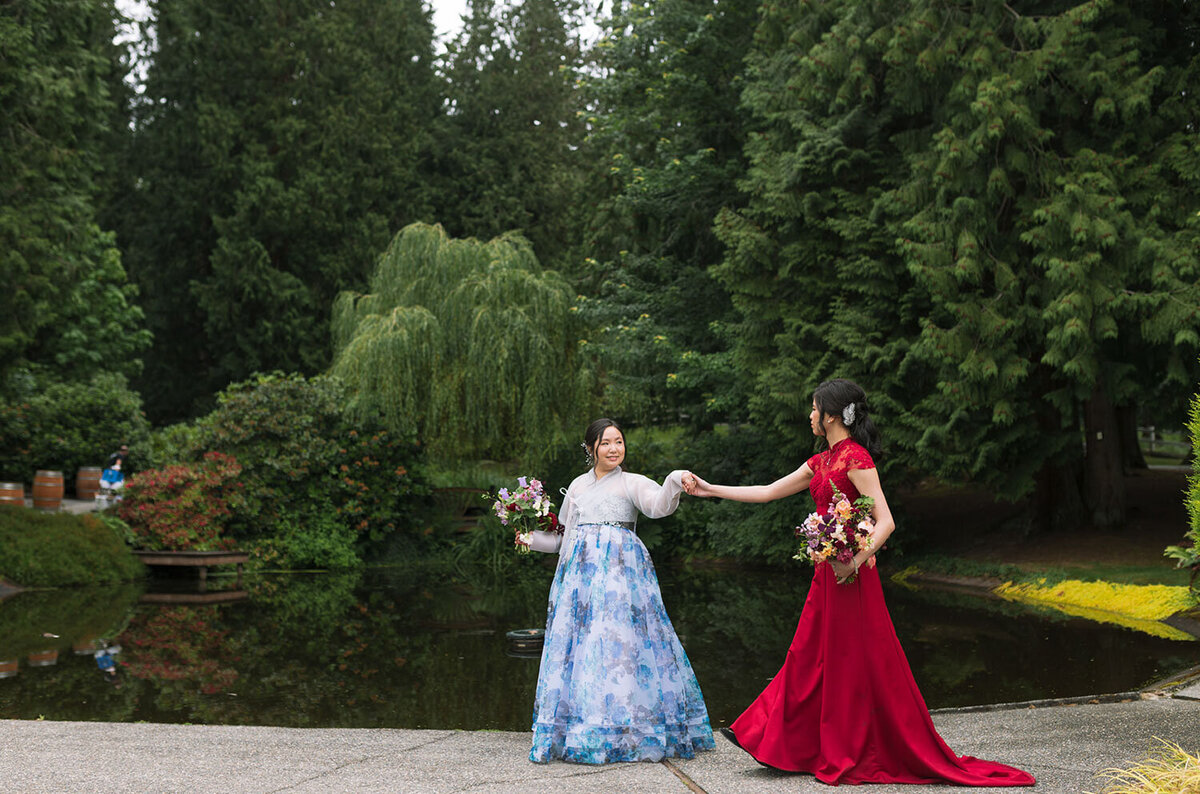 Gay couple in traditional dresses by a serene pond