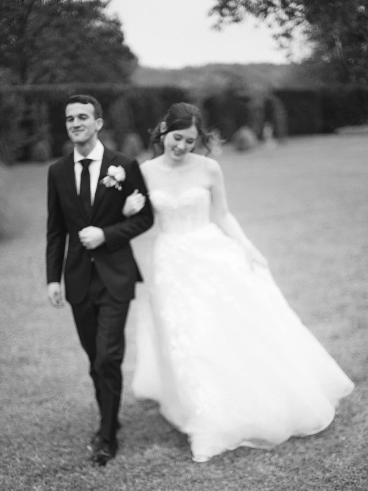 Candid photo of the bride and groom walking hand in hand, full of motion and emotion, by Paris wedding photographer Thomas Raboteur
