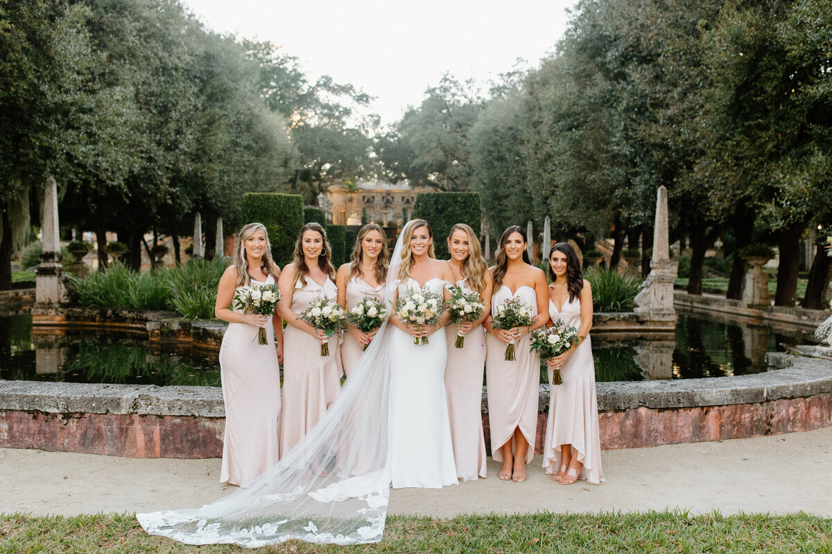 Bride and bridesmaids wearing light pink dresses at Vizcaya Museum and Gardens