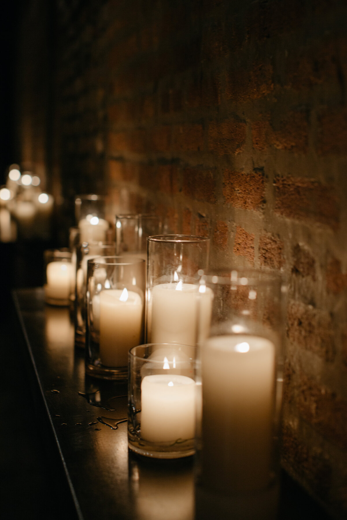 Up close image of candles of differing sizes lining the halls of Ada Restaurant in Chicago