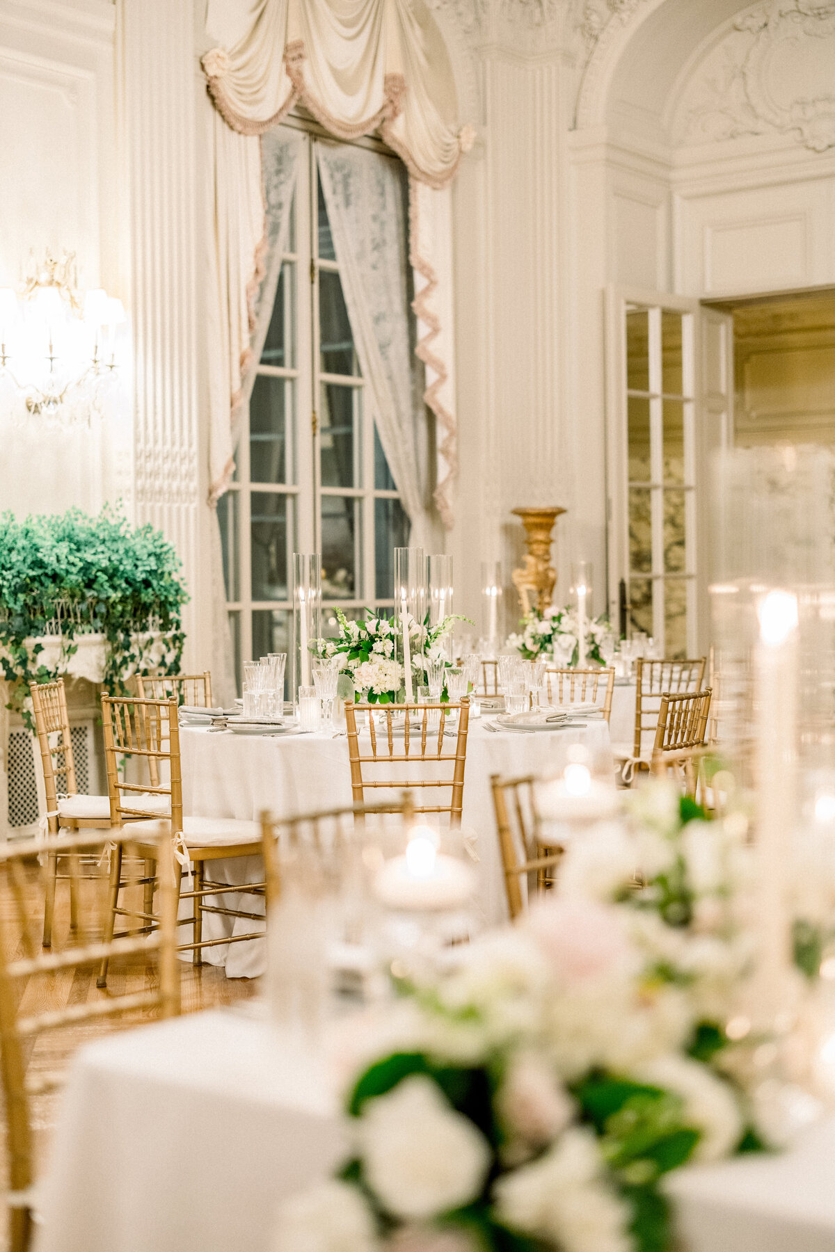 candle lit round tablescape  in ballroom of rosecliff mansion in newport rhode island