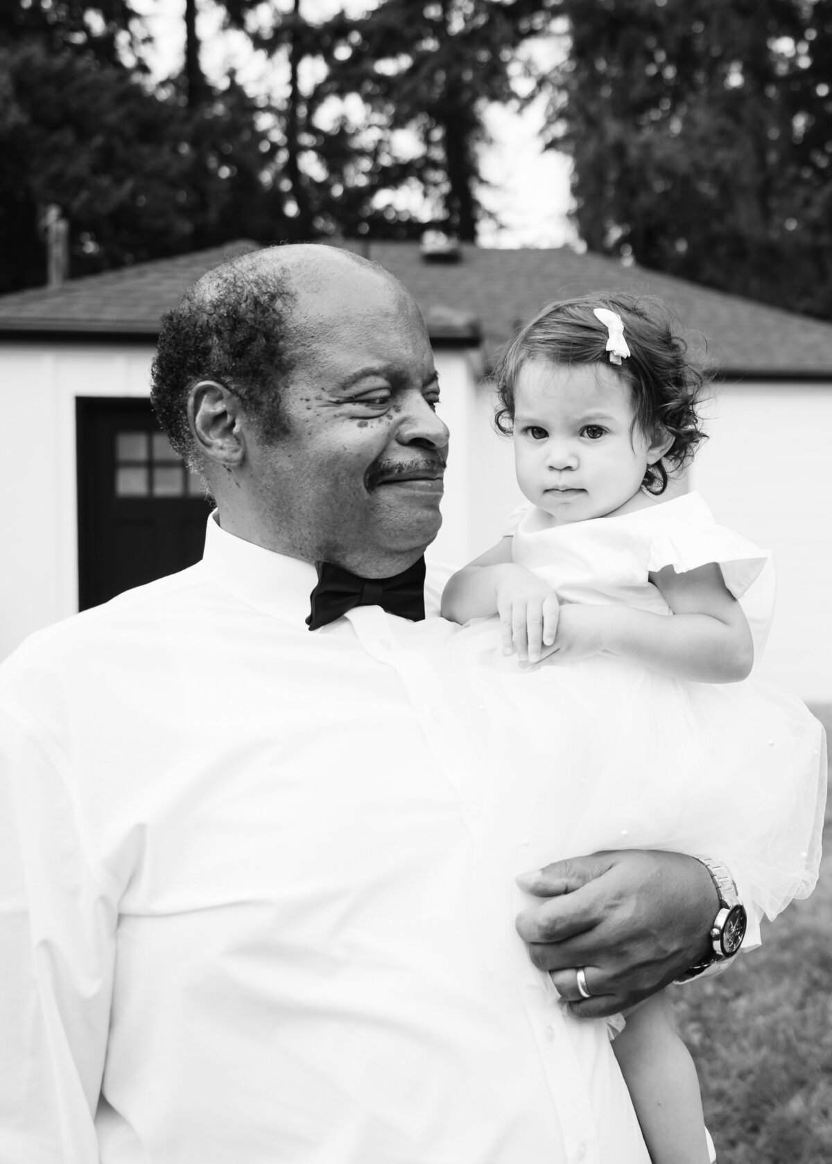 father of the bride with flower girl in black and white