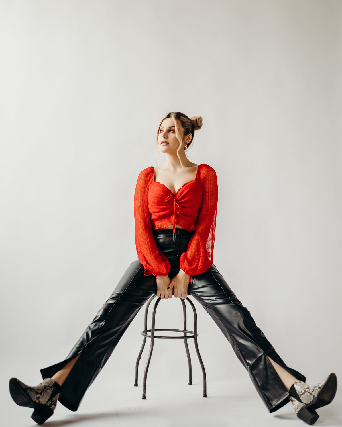 Girl in red shirt and black pants on a stool