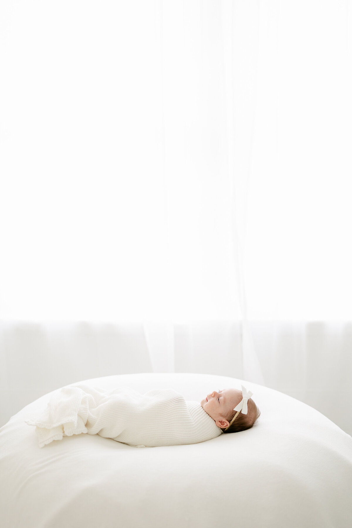 a newborn baby swaddled in white cloth