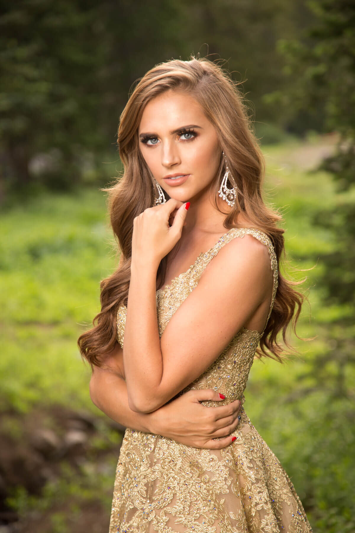 Senior girl posing in gold dress during golden hour in canyon in Utah by Albion Basin.