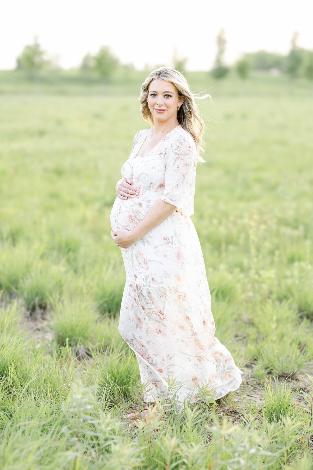 Outdoor maternity portrait of woman in a long dress