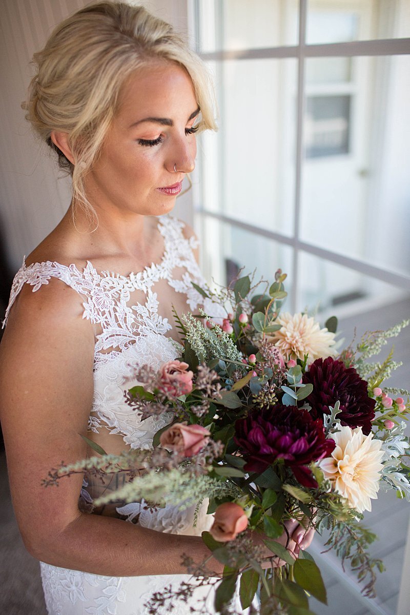 Stunning bride in lace dress holding Autumn bouquet