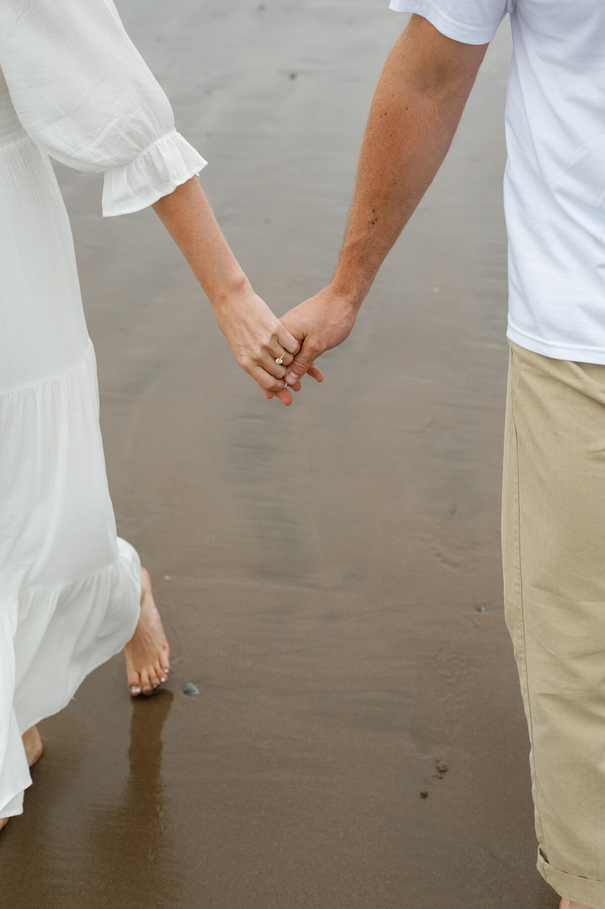 Couple holding hands at Conrad's Beach, Lawrencetown, NS