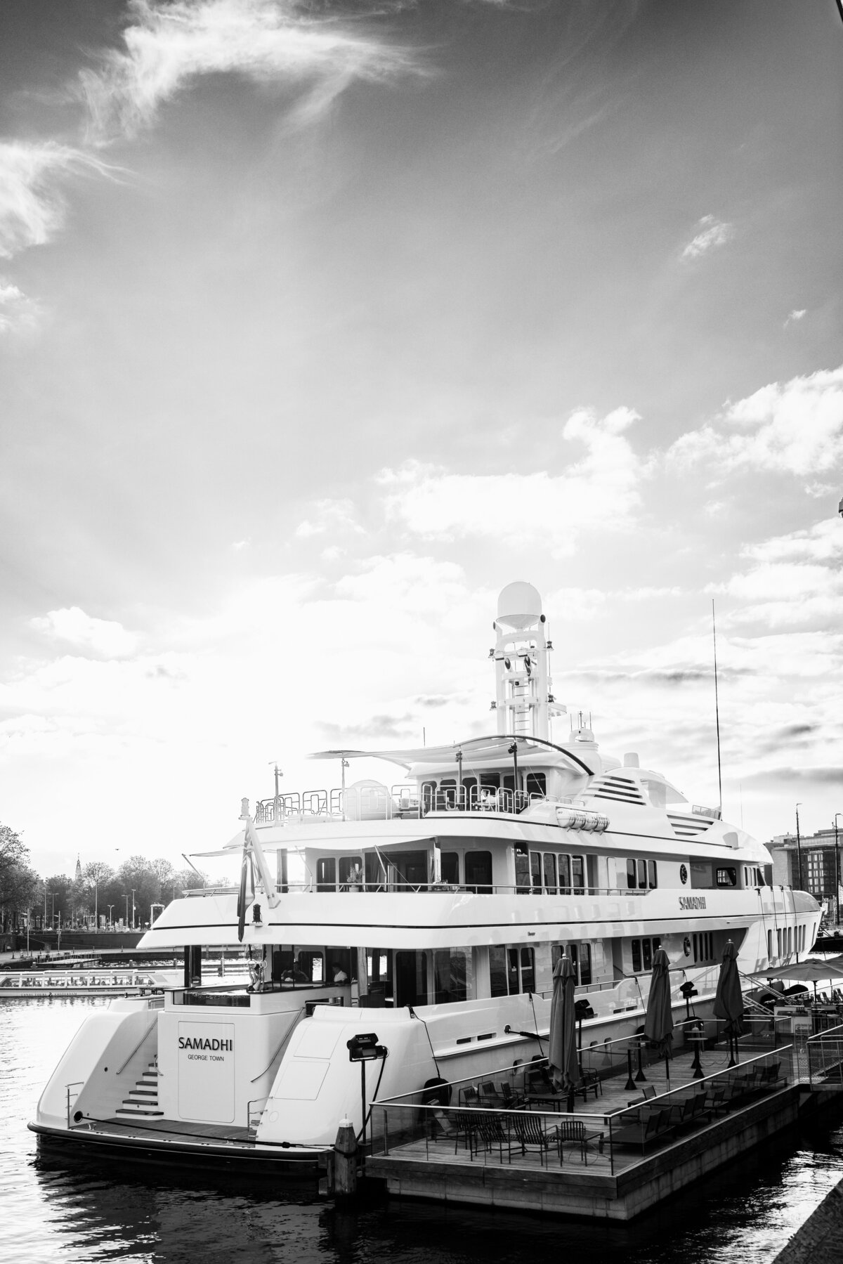 A stunning shot of the luxurious Samadhi yacht docked at the Scheepvaartmuseum in Amsterdam. The photo, taken during an exclusive event, captures the elegant design of the yacht against a serene sky. Ideal for showcasing high-end lifestyle and event photography.