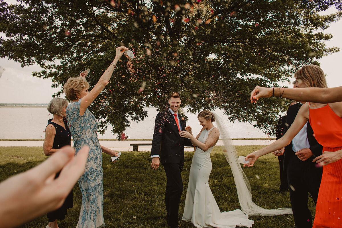 Wedding guests throwing seeds on a couple