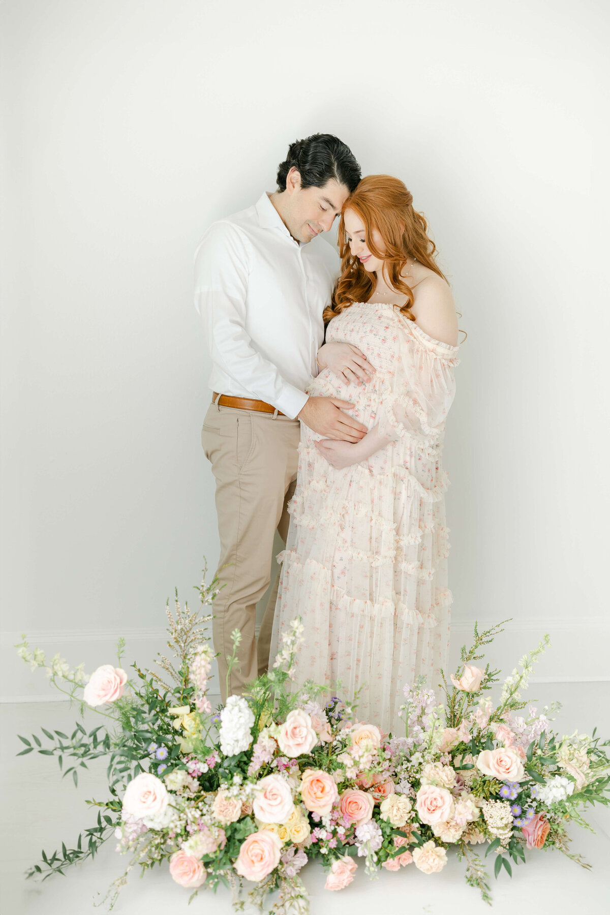 an expecting couple embracing