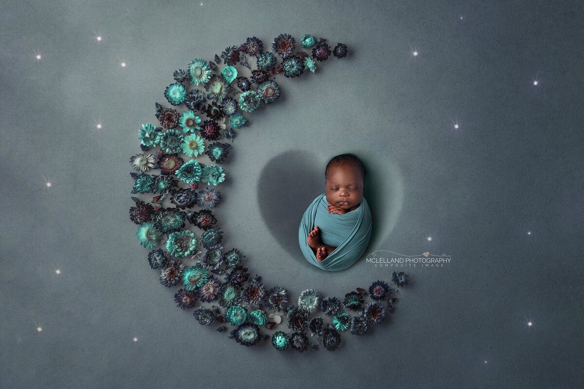 Newborn posed on a teal crescent moon — Burlington newborn photographer session