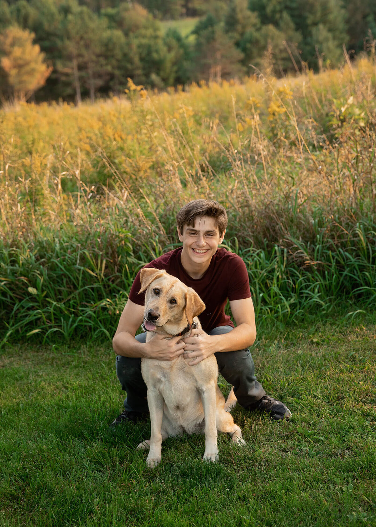 Senior boy hugging his yellow lab.