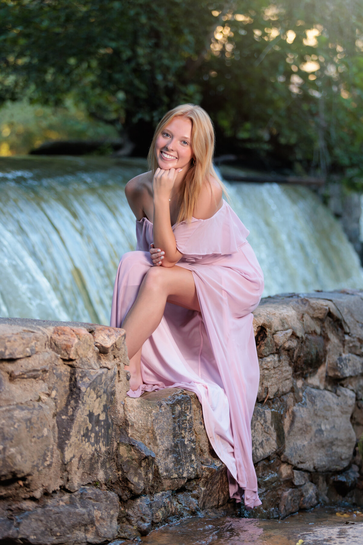 Waterfall in Raleigh, high school senior sitting on a rock wall.