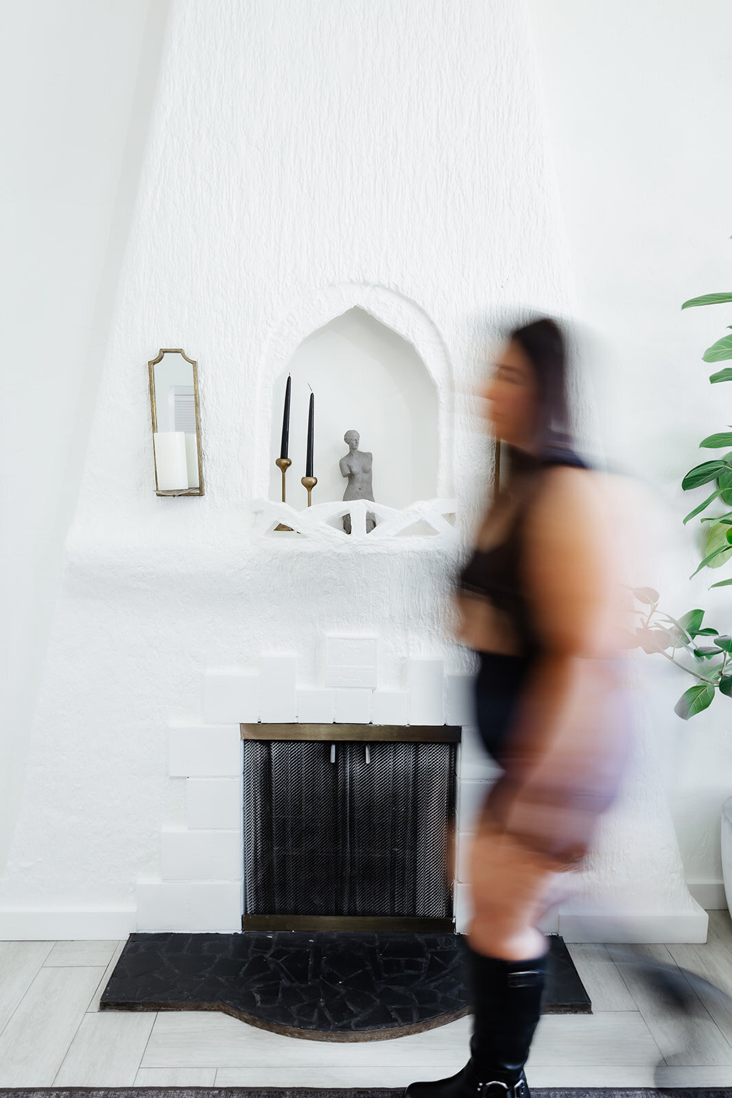 blurred woman walking past white wall
