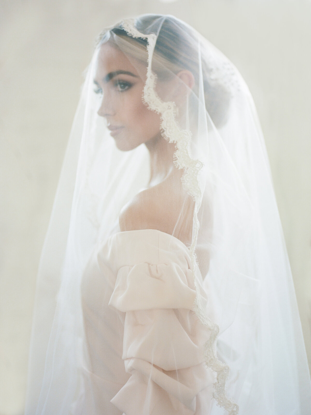 editorial image of bride wear veil over face