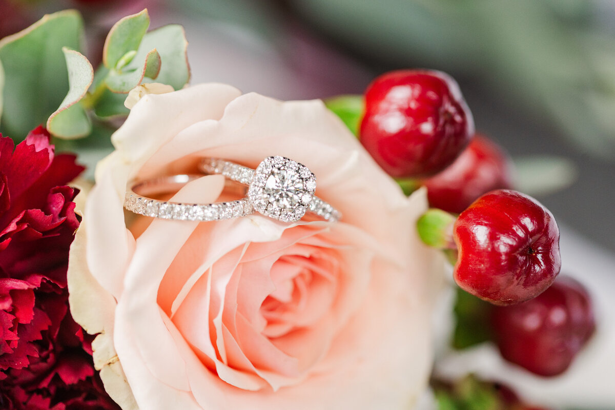 wedding rings resting on a rose in a flower bouquet