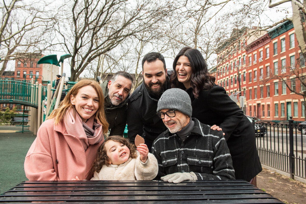 A family laughing as they sit at a picnic table together